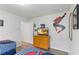 Bright bedroom with a Spiderman wall decoration, dresser with TV, and two beds with striped bedding at 5545 Misty Oak Cir, Davenport, FL 33837