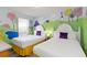 bedroom showcasing two twin beds, white headboards and a 'Dr. Seuss' themed mural on the walls at 5545 Misty Oak Cir, Davenport, FL 33837