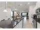 Open kitchen view showcasing the island, stainless appliances, tile floors and an open view to the living room at 5545 Misty Oak Cir, Davenport, FL 33837