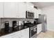 Modern kitchen features stainless steel appliances, granite countertops, and white cabinetry at 5545 Misty Oak Cir, Davenport, FL 33837