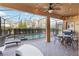 Inviting covered patio with ceiling fan, featuring an outdoor dining set and pool view at 5545 Misty Oak Cir, Davenport, FL 33837