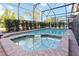 Inviting screened-in pool with a spa, surrounded by lush landscaping and ample deck space at 5545 Misty Oak Cir, Davenport, FL 33837