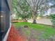 Sideyard showing mature trees, mulched flower bed, and partial view of the fenced backyard at 9525 Southern Garden Cir, Altamonte Springs, FL 32714