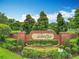 A brick sign at the Camden Club entrance features manicured landscaping, flowers and mature trees at 9525 Southern Garden Cir, Altamonte Springs, FL 32714