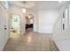 Inviting entryway featuring neutral tile flooring, an open staircase, and an arched doorway to the living area at 9525 Southern Garden Cir, Altamonte Springs, FL 32714