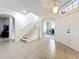Spacious entryway with tile flooring, staircase, and views into the home office space, creating a bright and welcoming ambiance at 9525 Southern Garden Cir, Altamonte Springs, FL 32714