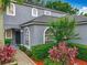 Gray house featuring arched windows, a black front door, and colorful landscaping at 9525 Southern Garden Cir, Altamonte Springs, FL 32714