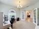 Bright home office featuring a chandelier, a large window, and an entrance into the living area at 9525 Southern Garden Cir, Altamonte Springs, FL 32714