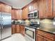 Kitchen featuring dark wood cabinetry, modern stainless steel appliances, and elegant granite countertops at 9525 Southern Garden Cir, Altamonte Springs, FL 32714
