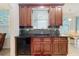 Cherry wood cabinets, black countertops, and black appliances make this kitchen sleek and modern at 9525 Southern Garden Cir, Altamonte Springs, FL 32714