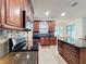 Spacious kitchen with dark wood cabinets, stainless steel appliances, and a view into the eat-in kitchen area at 9525 Southern Garden Cir, Altamonte Springs, FL 32714