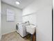 Well-lit laundry room featuring a modern washer and dryer, utility sink, and ample shelving at 9525 Southern Garden Cir, Altamonte Springs, FL 32714