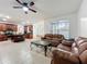 Open-concept living room featuring tile floors, fan, and adjacent kitchen with granite countertops at 9525 Southern Garden Cir, Altamonte Springs, FL 32714