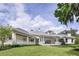 Well maintained yard featuring a home with a white exterior, grey roof, and covered patio at 8707 Nw 31St Lane Rd, Ocala, FL 34482