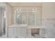 Beautiful bathroom featuring marble floors, dual sink vanity with elegant mirrors and light fixtures at 8707 Nw 31St Lane Rd, Ocala, FL 34482