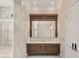Bathroom with a white marble floor, stone walls, dark wood cabinet and mirror over the vanity at 8707 Nw 31St Lane Rd, Ocala, FL 34482