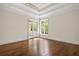 Bright bedroom with hardwood floors, large window, and door that leads to a balcony at 8707 Nw 31St Lane Rd, Ocala, FL 34482