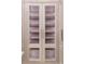 Custom walk-in closet features adjustable glass shelving, ambient lighting, and classic paneled-door design at 8707 Nw 31St Lane Rd, Ocala, FL 34482