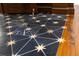 Detail shot of exquisite geometric marble flooring, highlighted by gold star accents and warm hardwood trim at 8707 Nw 31St Lane Rd, Ocala, FL 34482