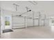 Spacious four-car garage with high ceilings, white walls and door leading to the backyard at 8707 Nw 31St Lane Rd, Ocala, FL 34482