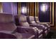Home theater showcasing plush seating, individual cup holders, and custom wall sconces for a cinematic experience at 8707 Nw 31St Lane Rd, Ocala, FL 34482