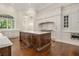 Gourmet kitchen boasts white cabinets, custom hood and a large island with marble countertop at 8707 Nw 31St Lane Rd, Ocala, FL 34482