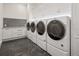 Spacious laundry area featuring modern appliances, sleek gray tile, and ample custom storage at 8707 Nw 31St Lane Rd, Ocala, FL 34482