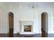 Elegant living room features white molding, a fireplace and hardwood floors with arched doorways on either side at 8707 Nw 31St Lane Rd, Ocala, FL 34482
