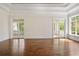 Elegant living room featuring hardwood floors, French doors, and large windows overlooking the backyard at 8707 Nw 31St Lane Rd, Ocala, FL 34482