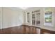 Bright room featuring hardwood floors, white trim, and views of the outdoors through multiple windows and glass doors at 8707 Nw 31St Lane Rd, Ocala, FL 34482