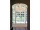 Bright living room features a crystal chandelier and a large window showcasing the property's extensive landscaping at 8707 Nw 31St Lane Rd, Ocala, FL 34482