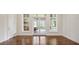 Sunlit living room featuring hardwood floors, large windows, glass panel doors and a neutral color scheme at 8707 Nw 31St Lane Rd, Ocala, FL 34482