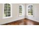 Bright room featuring hardwood floors, white trim, and multiple windows at 8707 Nw 31St Lane Rd, Ocala, FL 34482