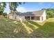 Spacious backyard featuring a screened-in lanai, mature trees, and ample space for outdoor activities at 294 Lake Doe Blvd, Apopka, FL 32703