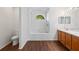 Bathroom boasts a tiled tub, shower, natural light window, and dual sink vanity at 294 Lake Doe Blvd, Apopka, FL 32703