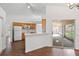 Open-concept kitchen with white appliances and a breakfast bar with a view of the patio at 294 Lake Doe Blvd, Apopka, FL 32703