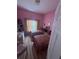 Bright bedroom with twin beds, colorful pink walls, and sliding glass door for natural light at 440 Bay Leaf Dr, Kissimmee, FL 34759