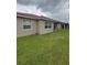 The rear exterior shows a window and a covered outdoor patio with a manicured lawn at 440 Bay Leaf Dr, Kissimmee, FL 34759