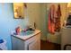 Bathroom featuring a turquoise sink, peeling walls, and outdated fixtures at 7043 Curtis Ave, Groveland, FL 34736