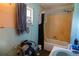 Bathroom featuring a bathtub with old fixtures, peeling walls, and a small window at 7043 Curtis Ave, Groveland, FL 34736