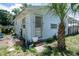Exterior view of the home showing weathered siding and a mature palm tree at 7043 Curtis Ave, Groveland, FL 34736