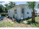 Exterior view of the home showing weathered siding, mature palm tree and entrance at 7043 Curtis Ave, Groveland, FL 34736