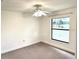 Simple bedroom with a window view of lush landscaping and a ceiling fan at 11315 Cypress Shore Ct, Clermont, FL 34711