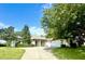 Charming single-story home featuring lush landscaping, a large driveway, and a welcoming entrance at 11315 Cypress Shore Ct, Clermont, FL 34711