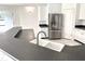 Bright kitchen with stainless steel refrigerator, white cabinets, and dark countertops at 11315 Cypress Shore Ct, Clermont, FL 34711
