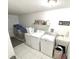 Functional laundry room featuring modern appliances and tiled flooring at 11315 Cypress Shore Ct, Clermont, FL 34711
