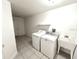 Bright laundry room featuring appliances and utility sink at 11315 Cypress Shore Ct, Clermont, FL 34711