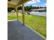 View of the backyard with a covered patio and well-maintained lawn with white fencing at 13074 Sw 104Th Ln, Dunnellon, FL 34432