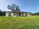 View of the back of house with green grass at 13074 Sw 104Th Ln, Dunnellon, FL 34432