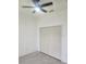 This bedroom features neutral tile flooring, white walls, and a ceiling fan, creating a clean and simple design at 13074 Sw 104Th Ln, Dunnellon, FL 34432
